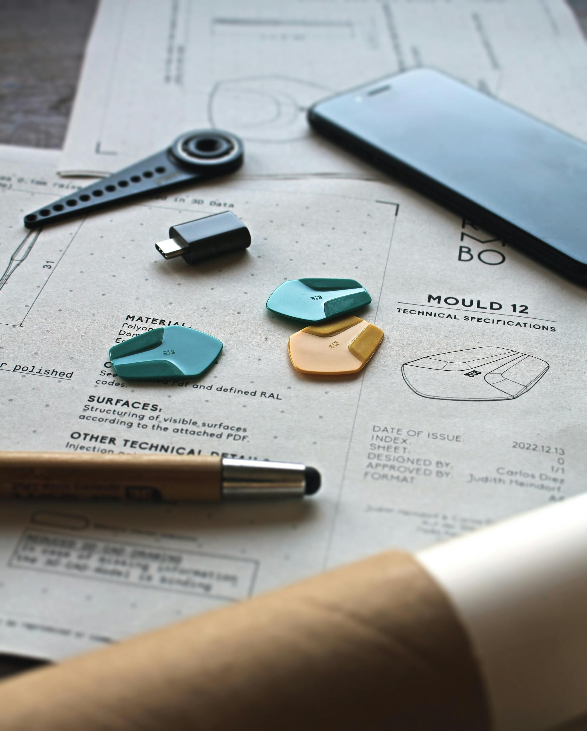 Close-up of a creative workspace featuring schematics, guitar picks, and design tools.